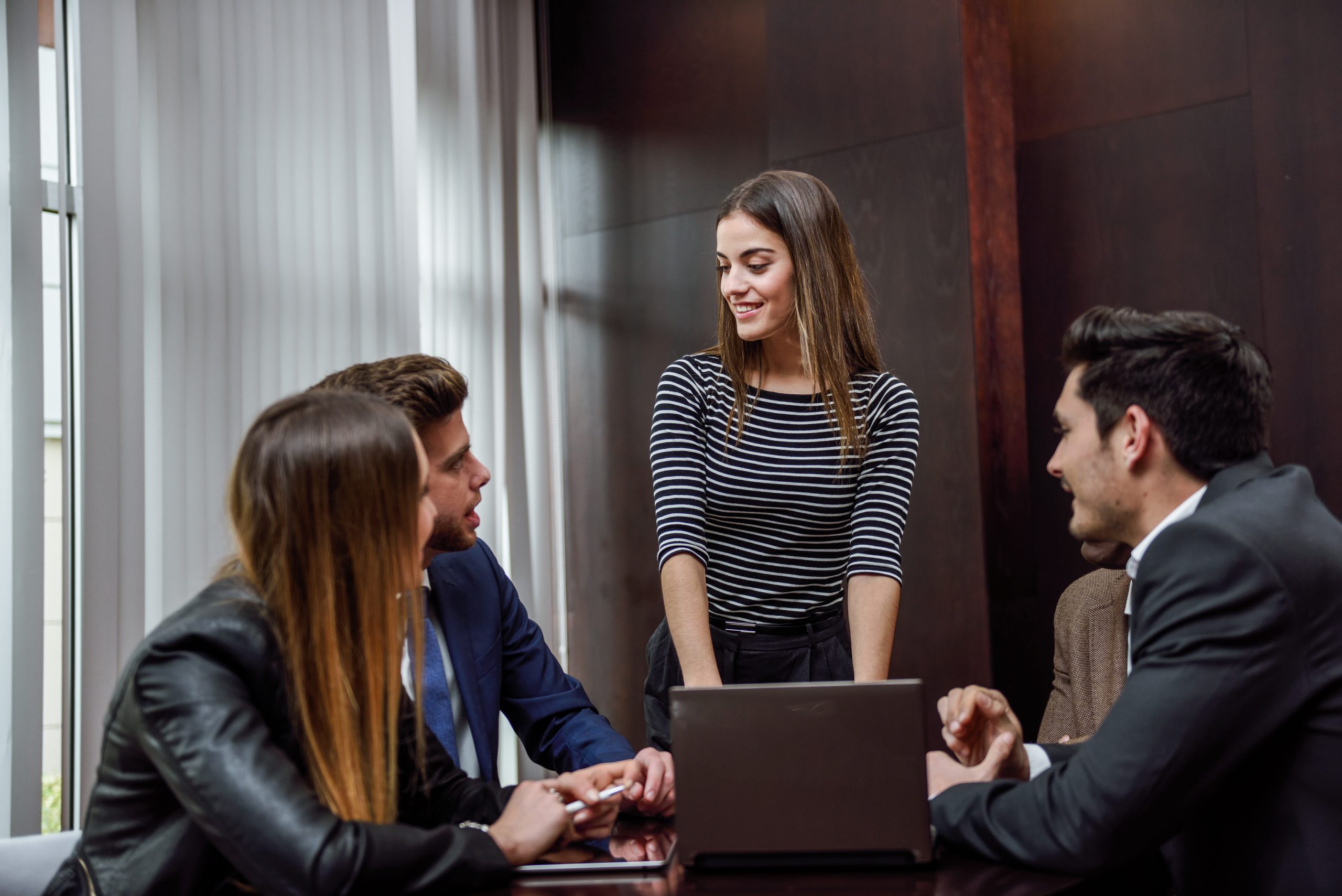 woman with laptop coworkers around scaled